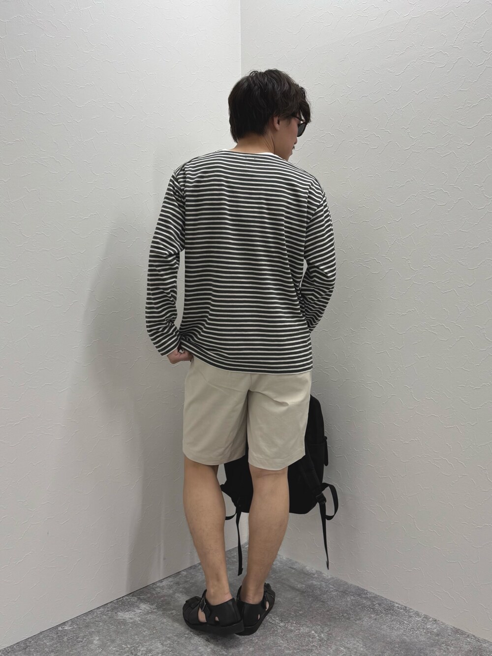 グレー系のTシャツ/カットソー、ホワイト系のその他パンツ、ブラック系のバックパック/リュックを着用したメンズの春コーディネートの7枚目の写真
