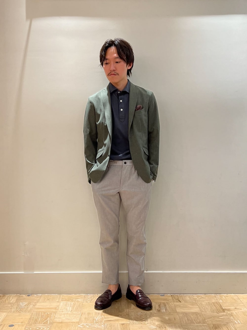 グリーン系のテーラードジャケット、グレー系のポロシャツ、ベージュ系のその他パンツを着用したメンズの夏コーディネートの2枚目の写真