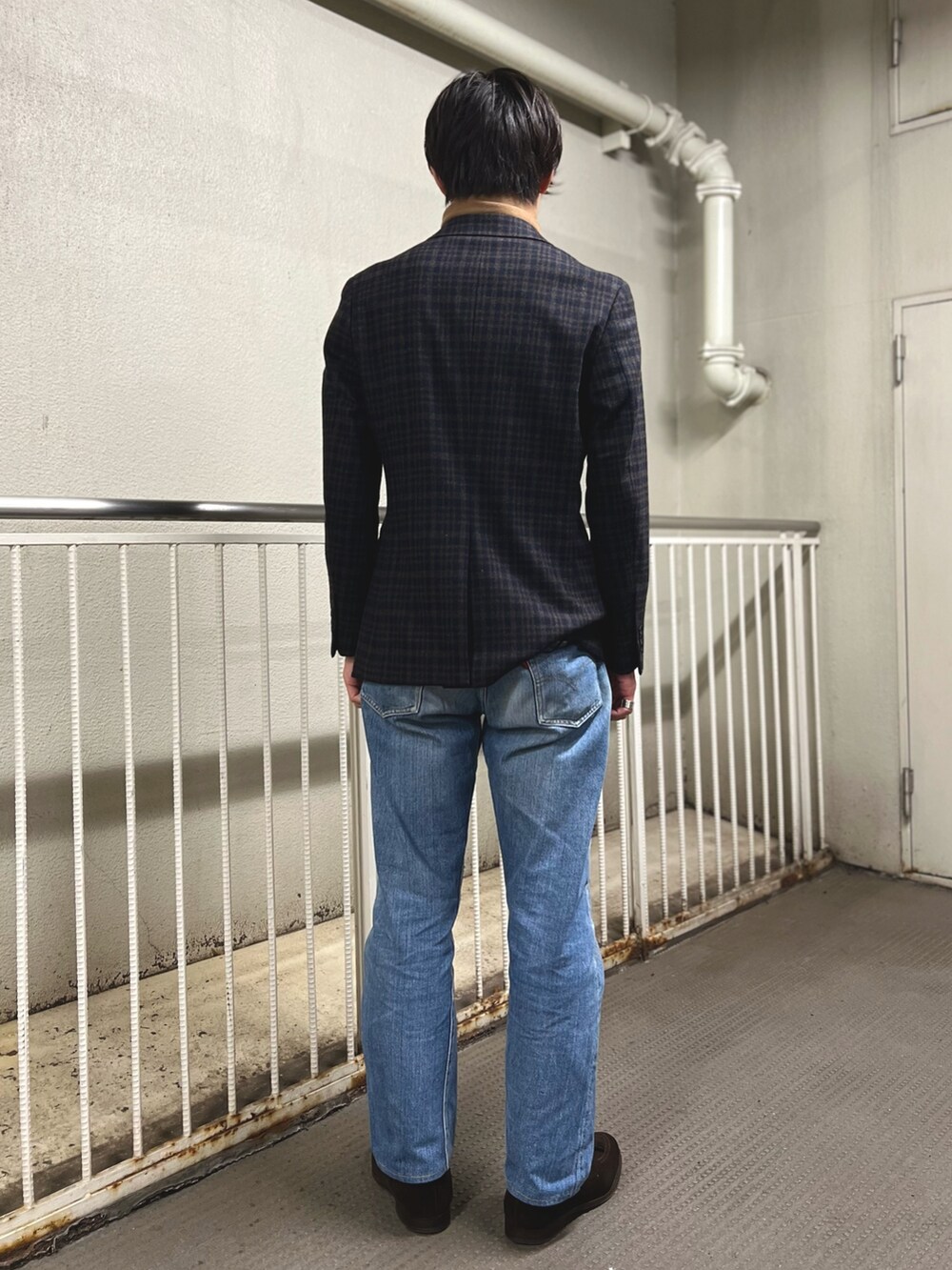 ブルー系のテーラードジャケット、ブラウン系のローファー、ブルー系のデニムパンツを着用したメンズの冬コーディネートの3枚目の写真