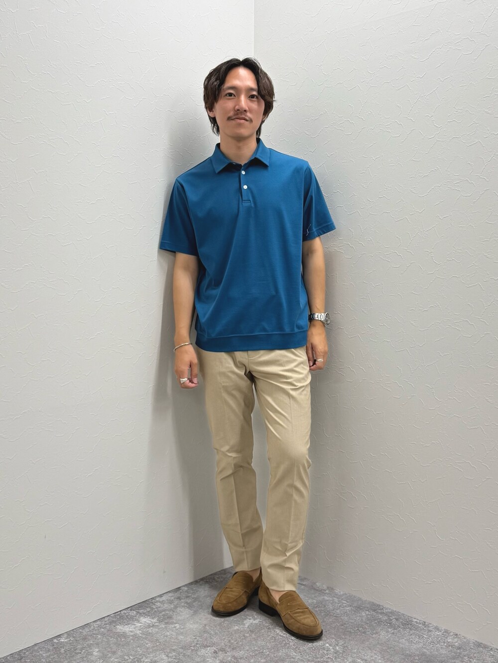 ブルー系のポロシャツ、ベージュ系のチノパンツ、ブルー系のテーラードジャケットを着用したメンズの夏コーディネートの4枚目の写真