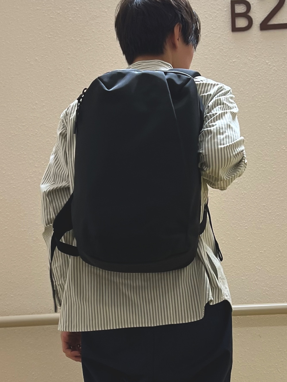 グリーン系のシャツ/ブラウス、ブラック系のバックパック/リュックを着用したメンズの秋コーディネートの3枚目の写真