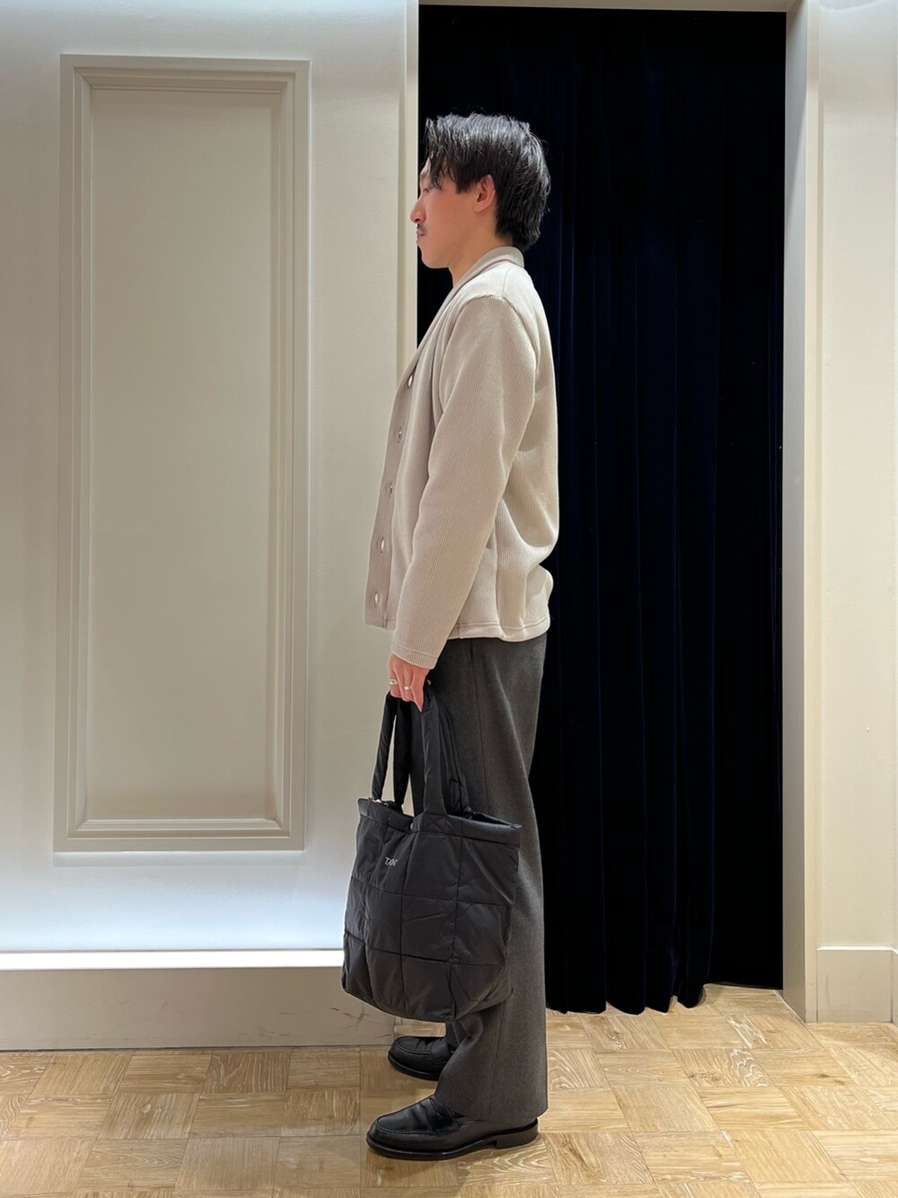 ベージュ系のカーディガン/ボレロ、ベージュ系のTシャツ/カットソー、ブラック系のトートバッグを着用したメンズの冬コーディネートの3枚目の写真