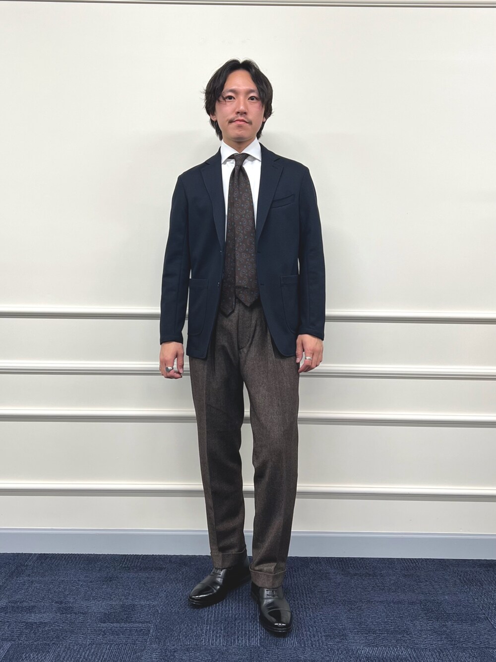 ブルー系のテーラードジャケット、ホワイト系のシャツ/ブラウス、ブラウン系のスラックスを着用したメンズの冬コーディネートの2枚目の写真