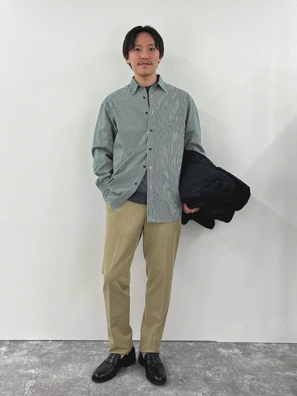 グリーン系のシャツ/ブラウス、ブラック系のブルゾン、グレー系のTシャツ/カットソーを着用したメンズの秋コーディネートの3枚目の写真