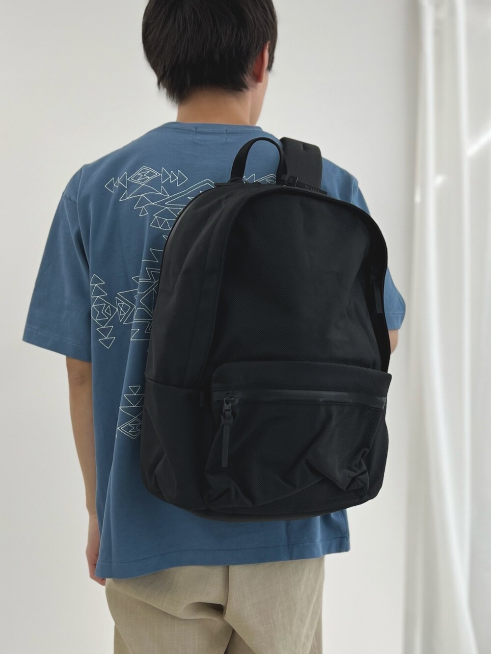 ブルー系のTシャツ/カットソー、ブラック系のバックパック/リュックを着用したメンズの春コーディネートの4枚目の写真