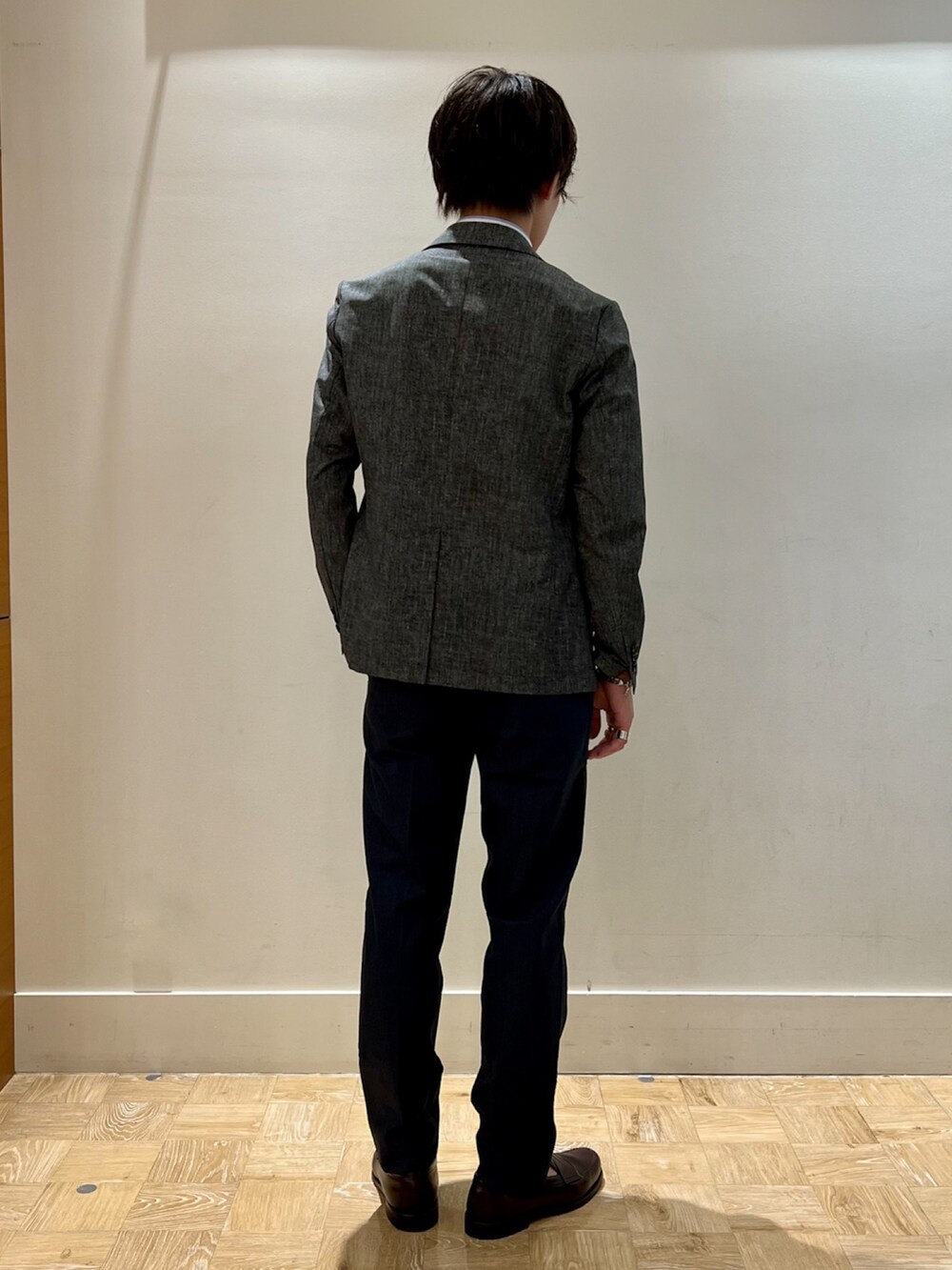 グレー系のテーラードジャケット、ホワイト系のポロシャツ、ブルー系のその他パンツを着用したメンズの夏コーディネートの4枚目の写真