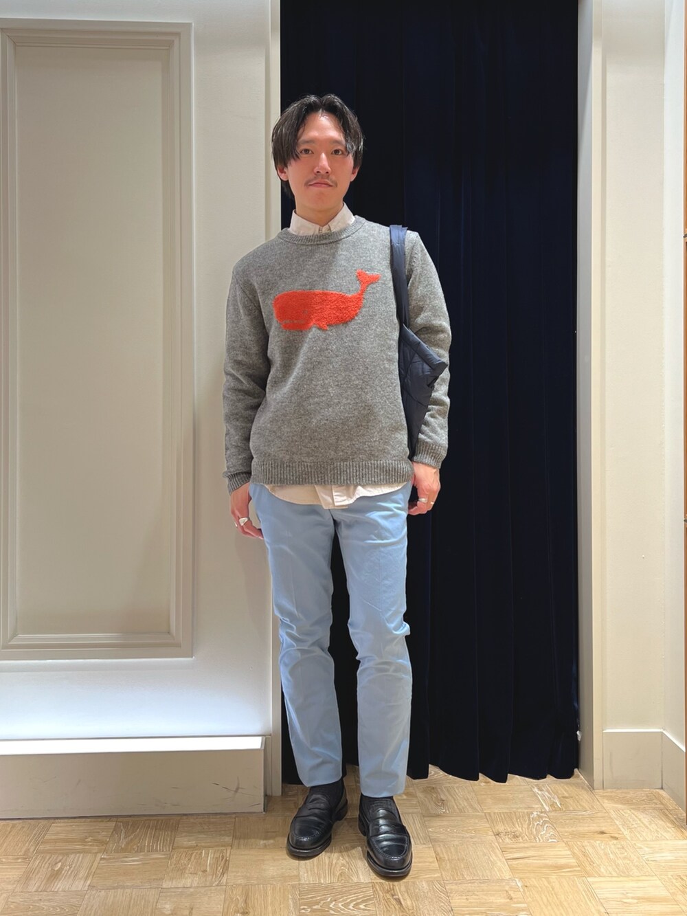 グレー系のニット/セーター、ベージュ系のシャツ/ブラウス、ブルー系のチノパンツを着用したメンズの冬コーディネートの3枚目の写真