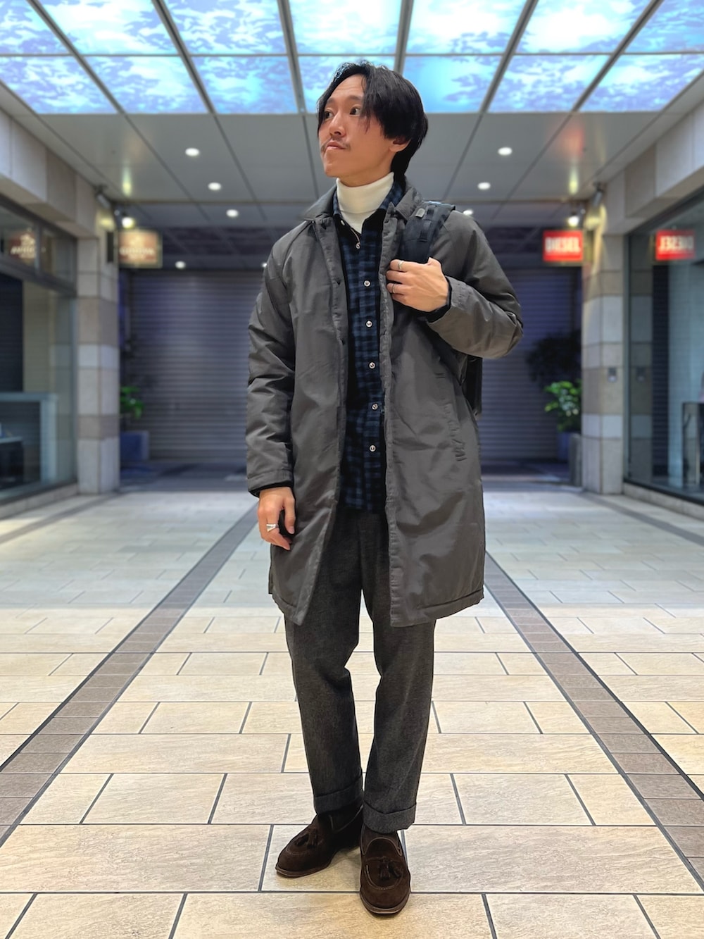 グレー系のダウンジャケット/コート、ブルー系のシャツ/ブラウス、ホワイト系のニット/セーターを着用したメンズの冬コーディネートの3枚目の写真