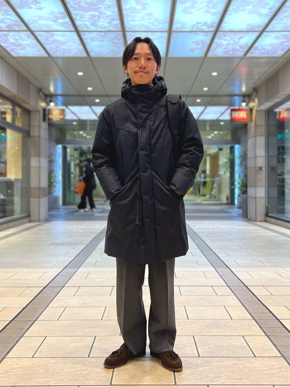 ブラック系のダウンジャケット/コート、ブラック系のバックパック/リュックを着用したメンズの冬コーディネートの2枚目の写真