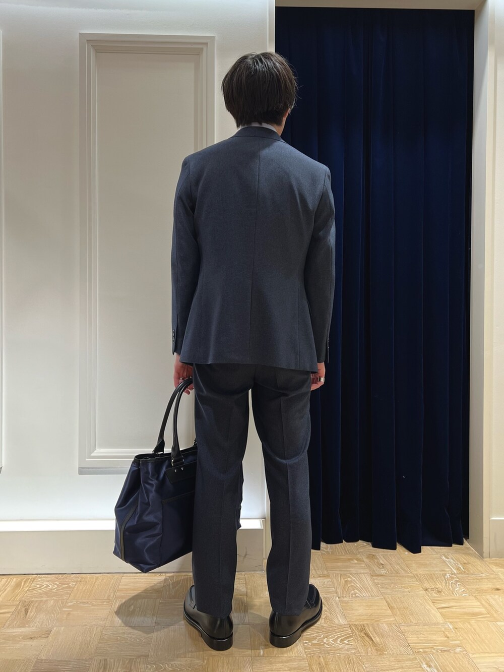 ブラック系のローファー、ブルー系のベスト、ブルー系のネクタイを着用したメンズの秋コーディネートの3枚目の写真