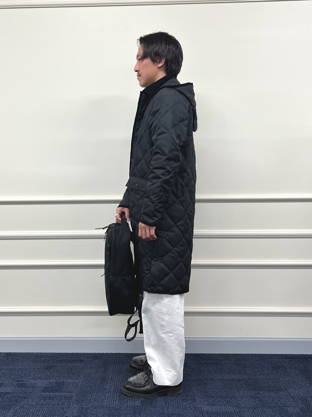 ブラック系のダウンジャケット/コート、ブラック系のバックパック/リュック、ベージュ系のカーディガン/ボレロを着用したメンズの冬コーディネートの7枚目の写真