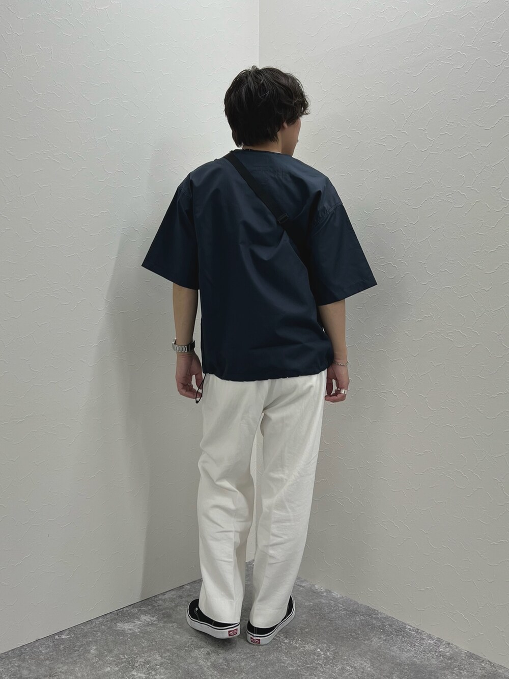 ブルー系のTシャツ/カットソー、ブラック系のショルダーバッグ、ホワイト系のデニムパンツを着用したメンズの春コーディネートの4枚目の写真