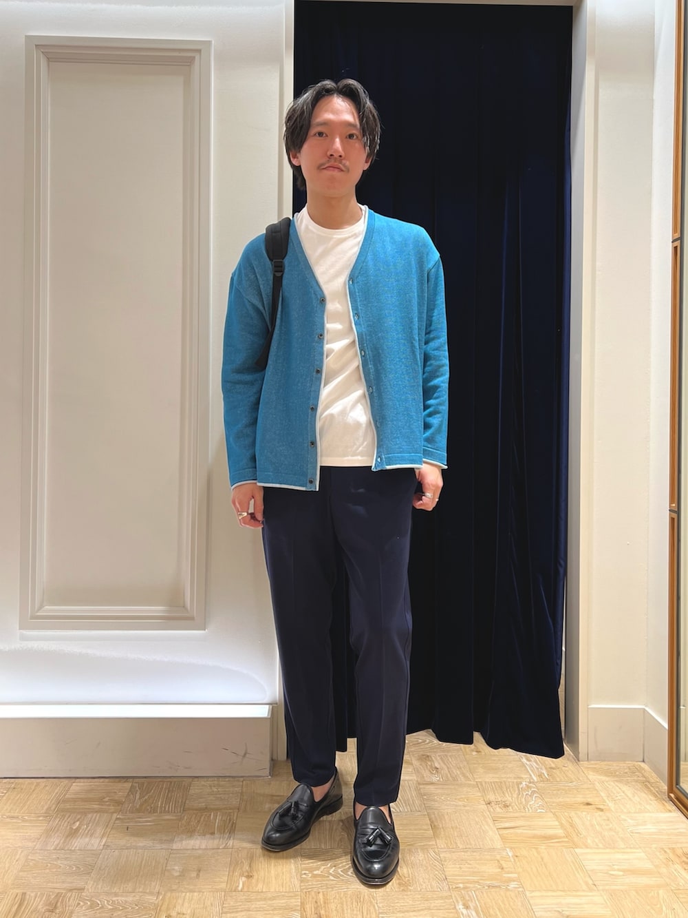 グリーン系のカーディガン/ボレロ、ブラック系のバックパック/リュックを着用したメンズの冬コーディネートの3枚目の写真