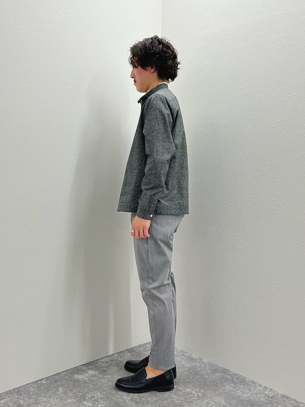 グレー系のブルゾン、ホワイト系のTシャツ/カットソー、グレー系のチノパンツを着用したメンズの冬コーディネートの5枚目の写真