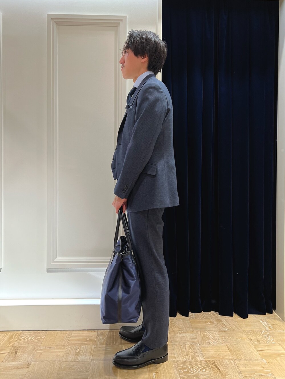 ブラック系のローファー、ブルー系のベスト、ブルー系のネクタイを着用したメンズの秋コーディネートの2枚目の写真