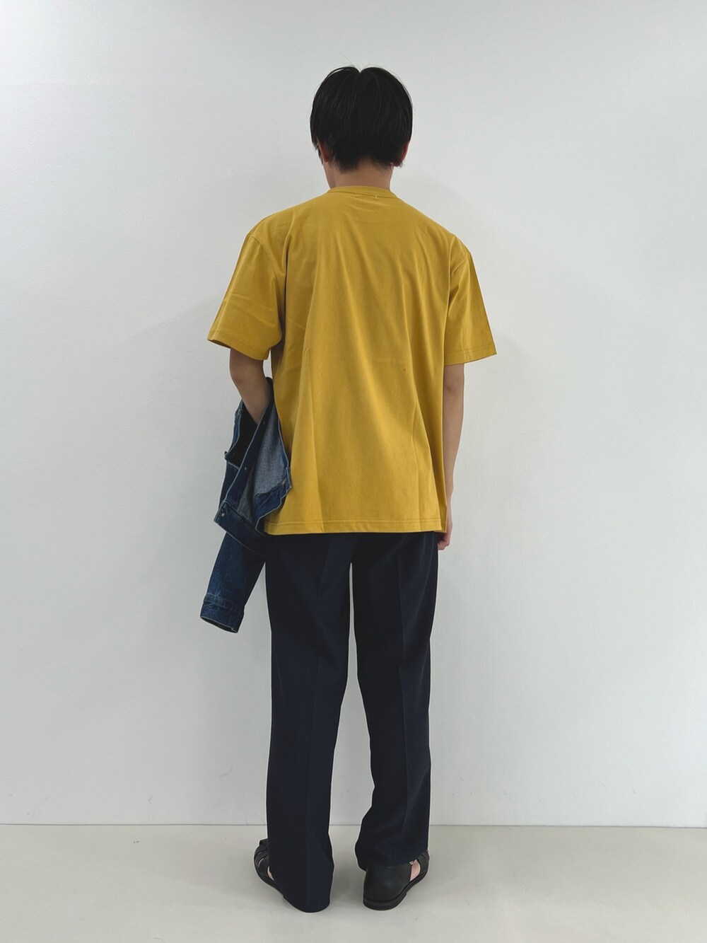 イエロー系のTシャツ/カットソー、ブルー系のデニムジャケット、ブラック系のその他パンツを着用したメンズの春コーディネートの2枚目の写真