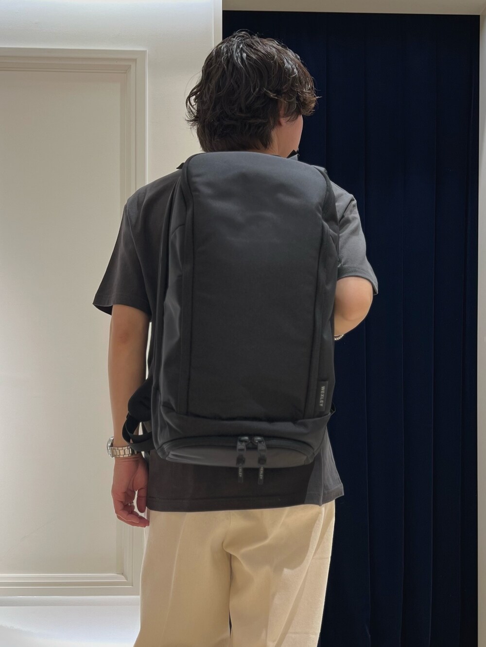 ブラック系のTシャツ/カットソー、ブラック系のバックパック/リュック、ブラック系のスニーカーを着用したメンズの春コーディネートの8枚目の写真