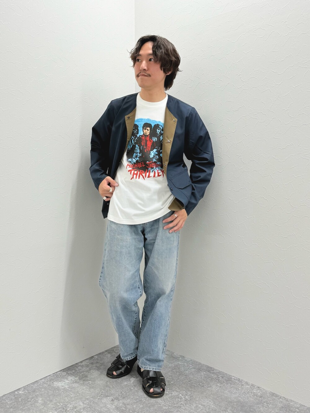 ブルー系のブルゾン、ホワイト系のTシャツ/カットソー、ブラック系のサンダルを着用したメンズの春コーディネートの2枚目の写真