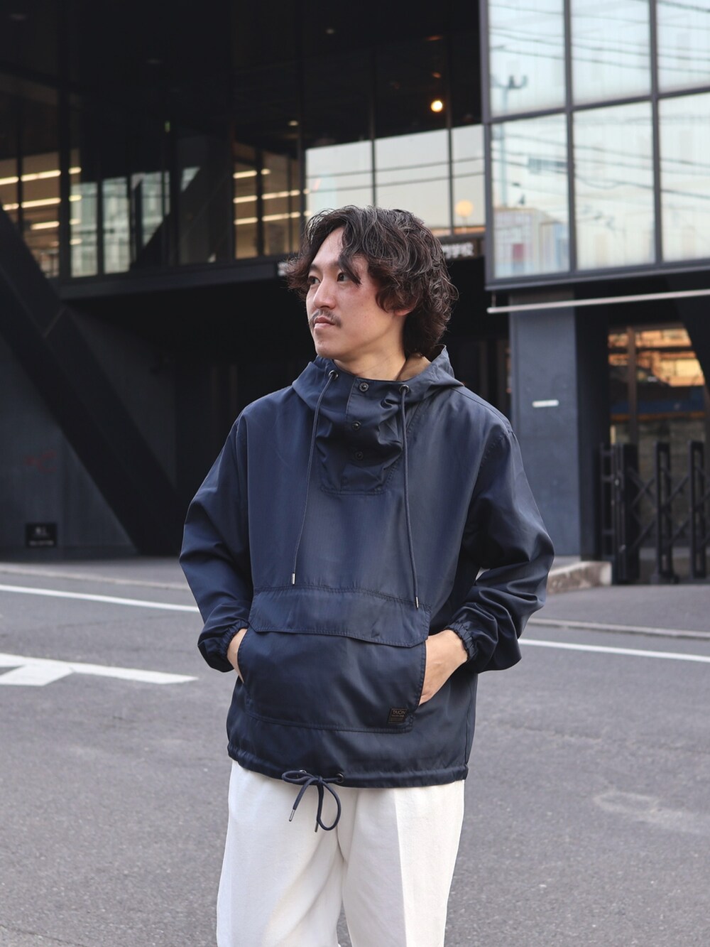 ブルー系のブルゾン、ホワイト系のデニムパンツ、ホワイト系のスニーカーを着用したメンズの春コーディネートの2枚目の写真