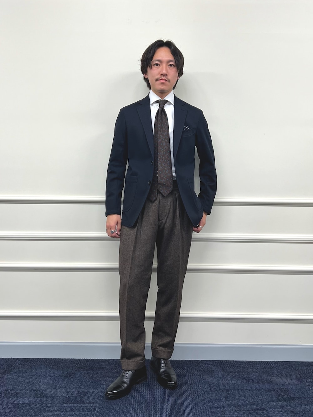 ブルー系のテーラードジャケット、ホワイト系のシャツ/ブラウス、ブラウン系のスラックスを着用したメンズの冬コーディネートの3枚目の写真