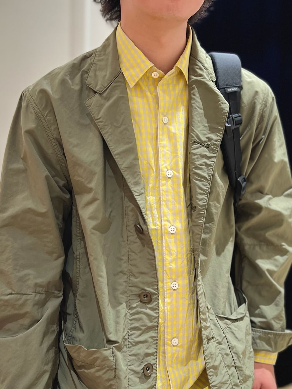 グリーン系のミリタリージャケット、レッド系のローファー、ホワイト系のデニムパンツを着用したメンズの春コーディネートの6枚目の写真