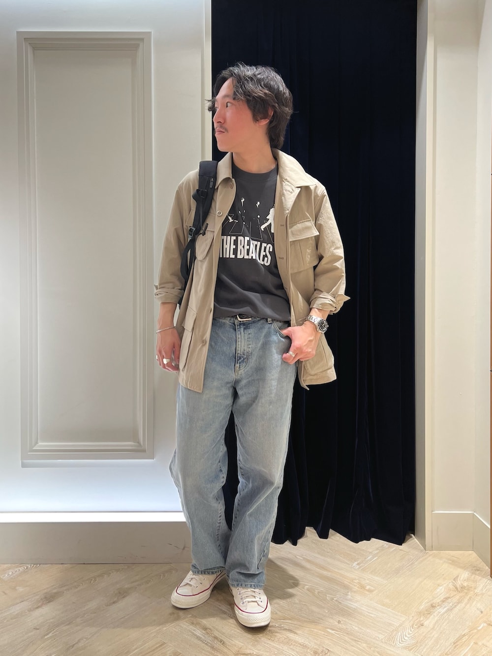 ベージュ系のミリタリージャケット、ブラック系のTシャツ/カットソー、ブラック系のバックパック/リュックを着用したメンズの春コーディネートの6枚目の写真