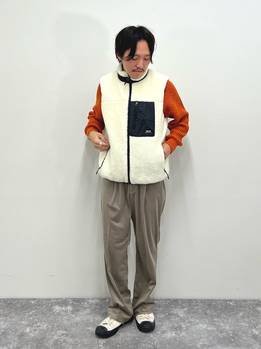 ホワイト系のダウンベスト、ベージュ系のその他パンツを着用したメンズの秋コーディネートの5枚目の写真