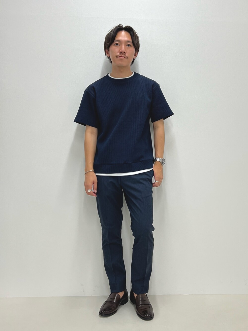 ブルー系のTシャツ/カットソー、ブルー系のチノパンツ、ブラウン系のローファーを着用したメンズの夏コーディネートの3枚目の写真