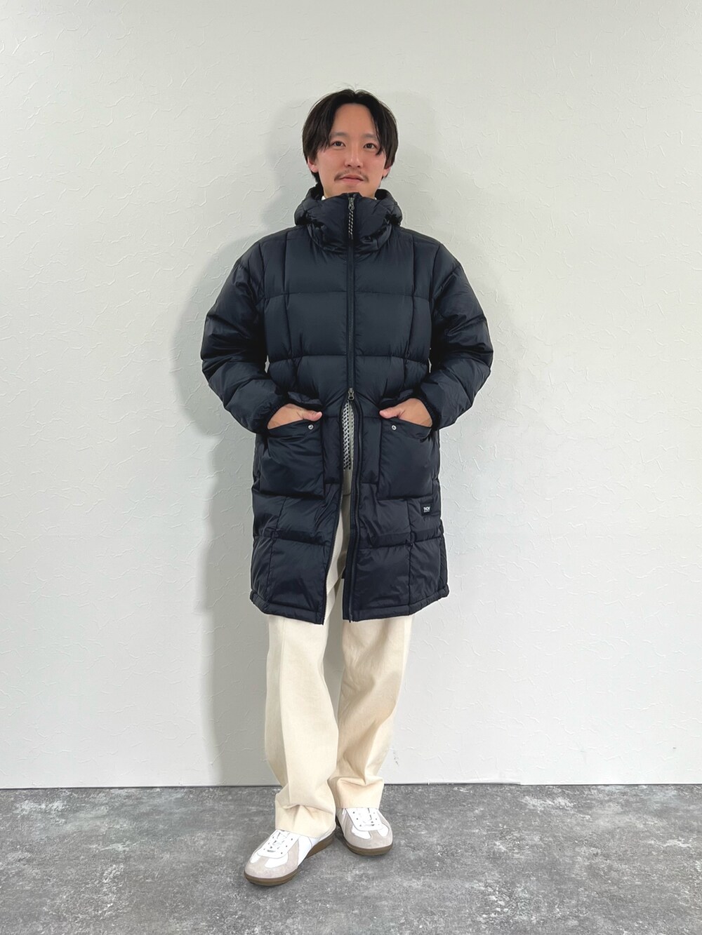 ブラック系のダウンジャケット/コート、ホワイト系のカーディガン/ボレロ、ホワイト系のTシャツ/カットソーを着用したメンズの冬コーディネートの4枚目の写真