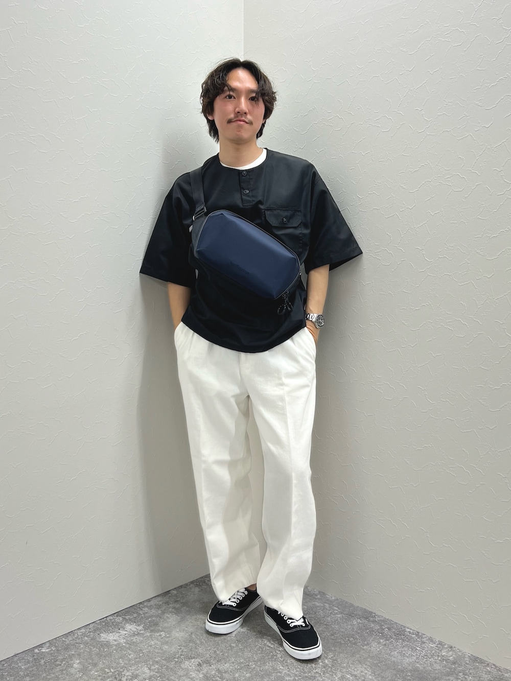 ブラック系のTシャツ/カットソー、ブルー系のショルダーバッグ、ホワイト系のデニムパンツを着用したメンズの春コーディネートの2枚目の写真