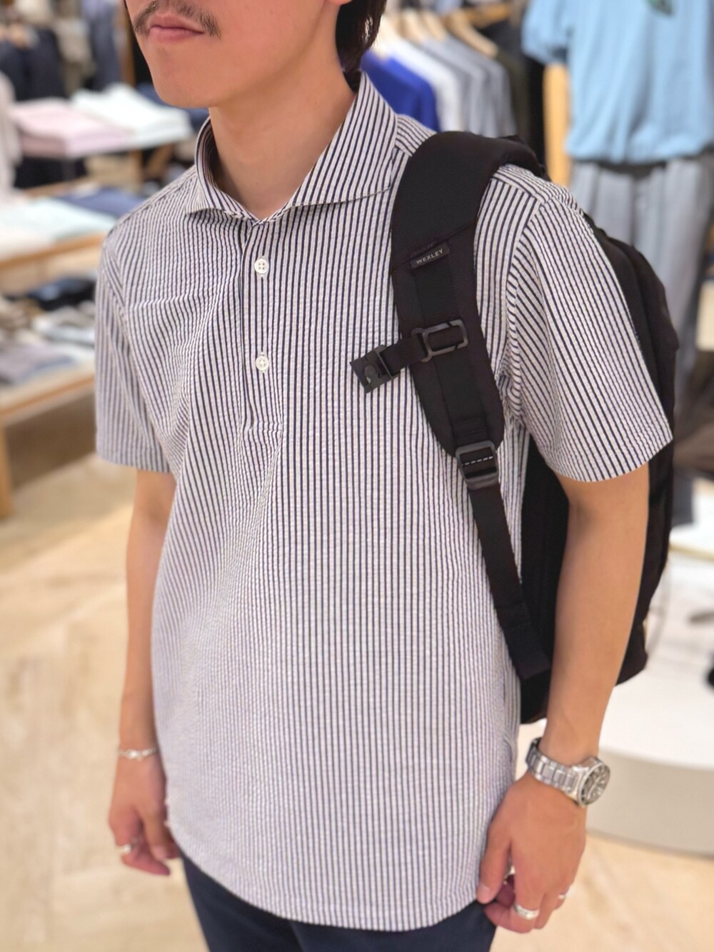 ブルー系のポロシャツ、ブルー系のその他パンツ、ブラック系のバックパック/リュックを着用したメンズの夏コーディネートの7枚目の写真