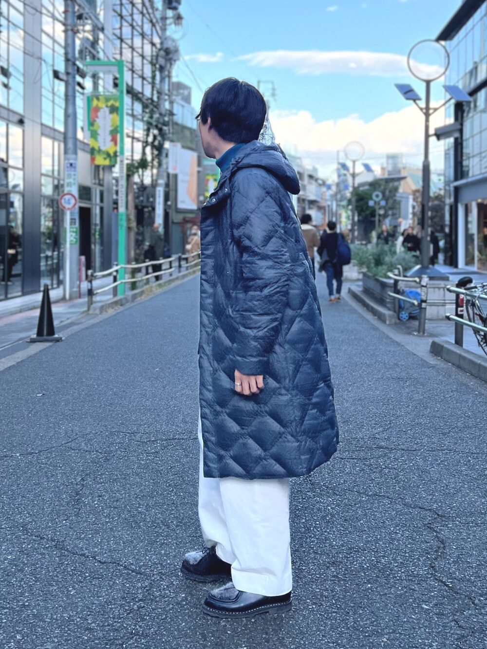 グレー系のダウンジャケット/コート、ブルー系のニット/セーター、ホワイト系のデニムパンツを着用したメンズの冬コーディネートの5枚目の写真