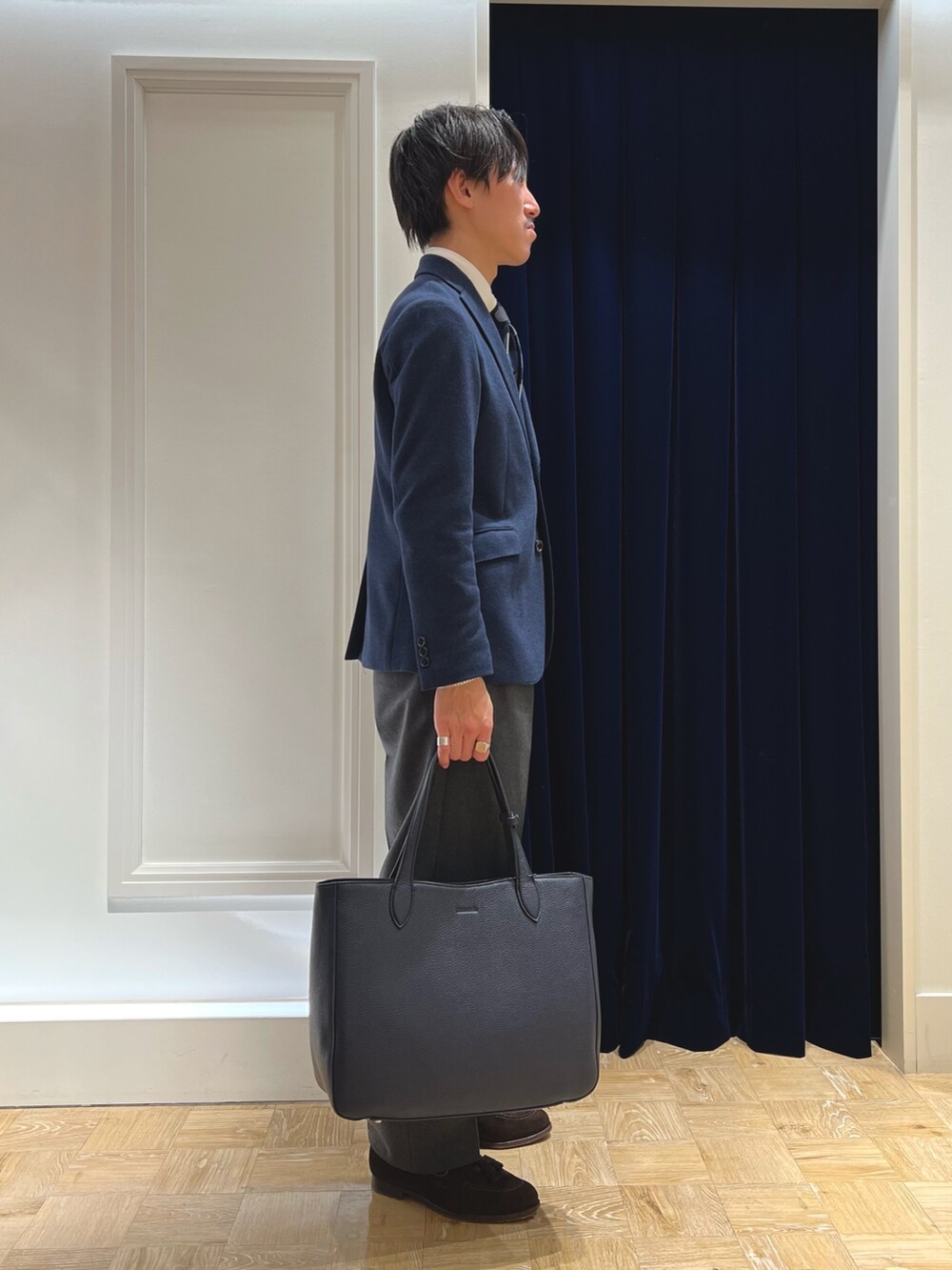 ブルー系のテーラードジャケット、ブルー系のネクタイ、ブルー系のトートバッグを着用したメンズの冬コーディネートの4枚目の写真