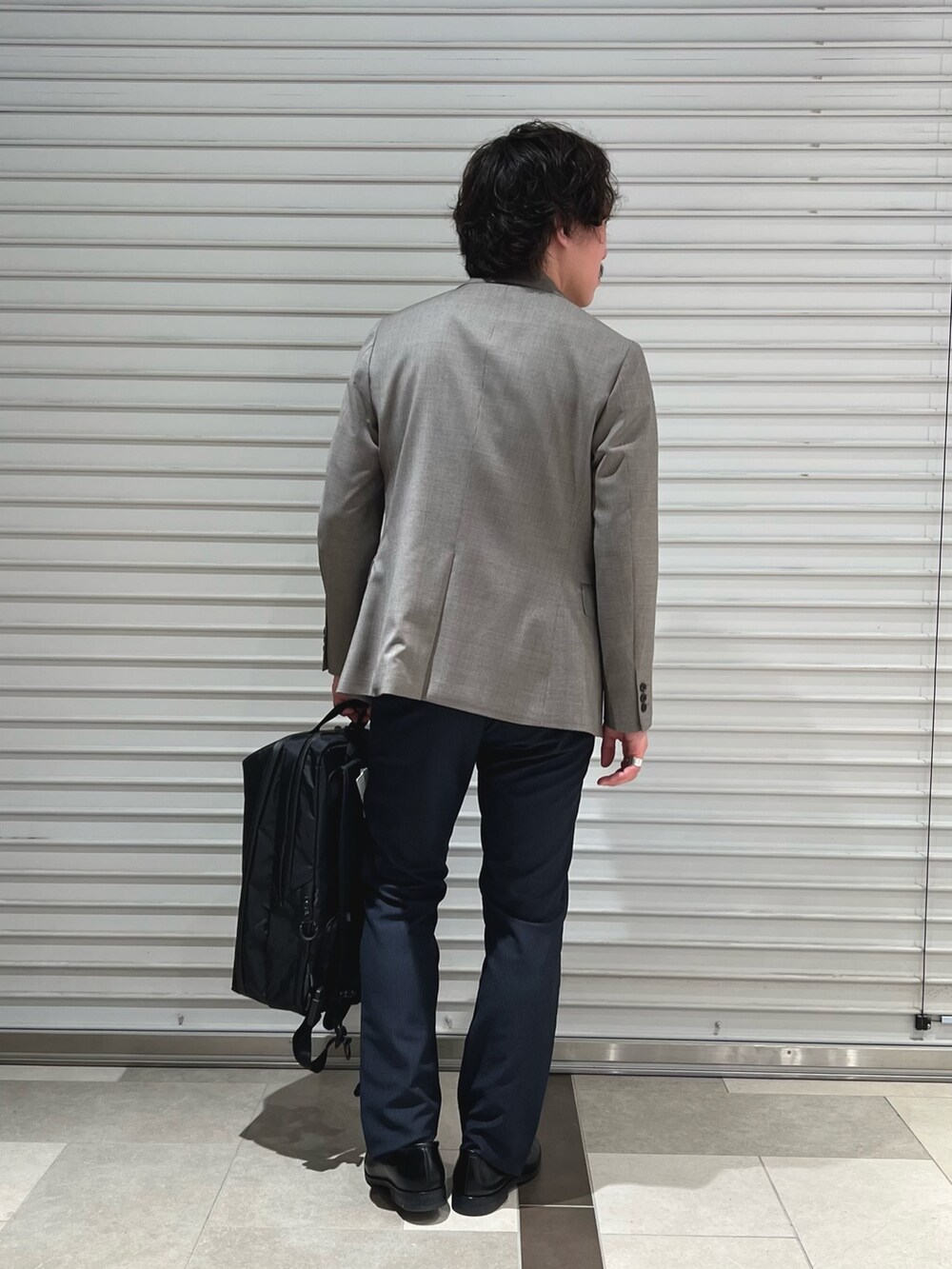 グレー系のテーラードジャケット、ホワイト系のTシャツ/カットソー、ブルー系のその他パンツを着用したメンズの春コーディネートの5枚目の写真