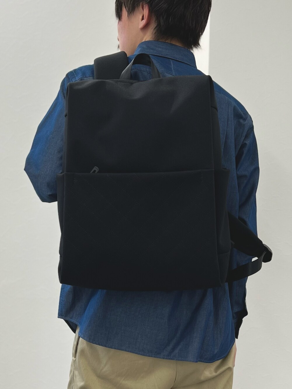 ブルー系のシャツ/ブラウス、ブラック系のバックパック/リュックを着用したメンズの春コーディネートの5枚目の写真