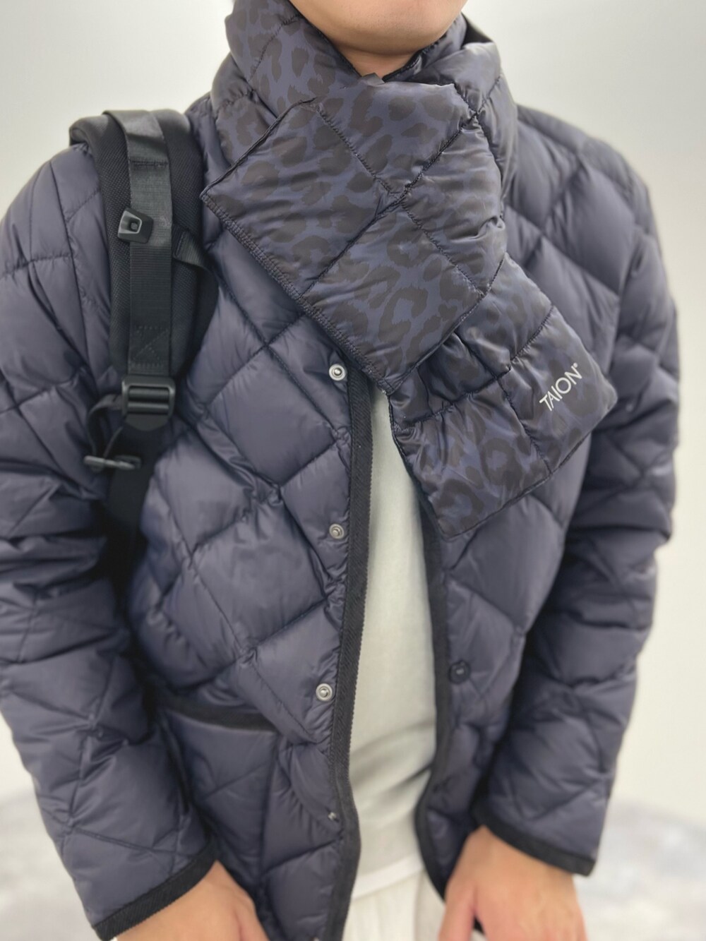 ブルー系のダウンジャケット/コート、グレー系のTシャツ/カットソー、ブルー系のマフラーを着用したメンズの秋コーディネートの6枚目の写真