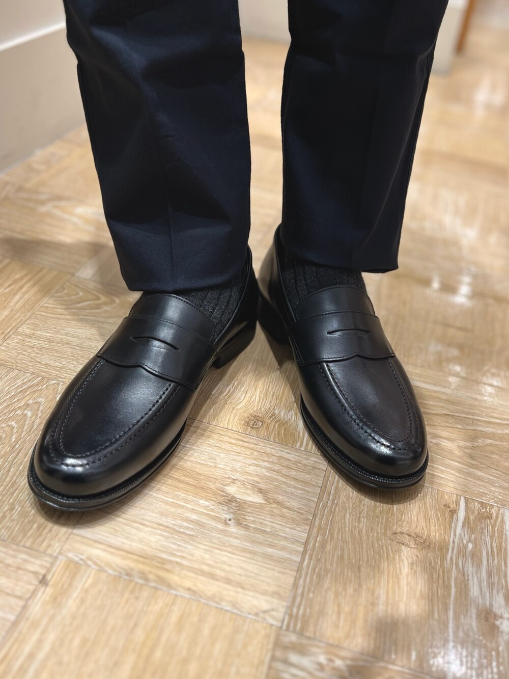 グレー系のダウンジャケット/コート、ブルー系のシャツ/ブラウス、ブラック系のローファーを着用したメンズの冬コーディネートの6枚目の写真