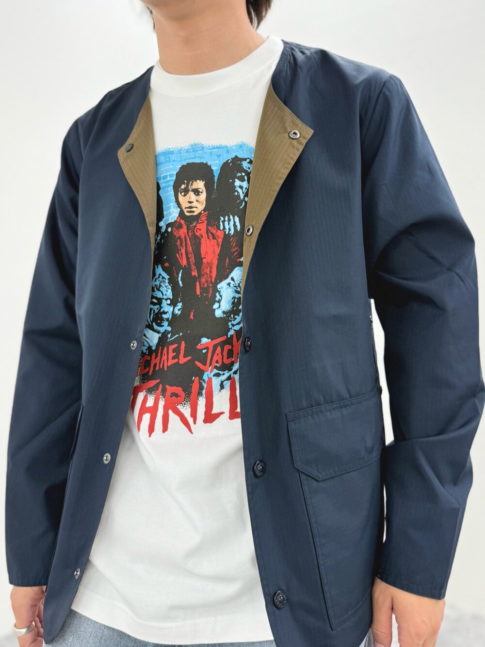 ブルー系のブルゾン、ホワイト系のTシャツ/カットソー、ブラック系のサンダルを着用したメンズの春コーディネートの7枚目の写真
