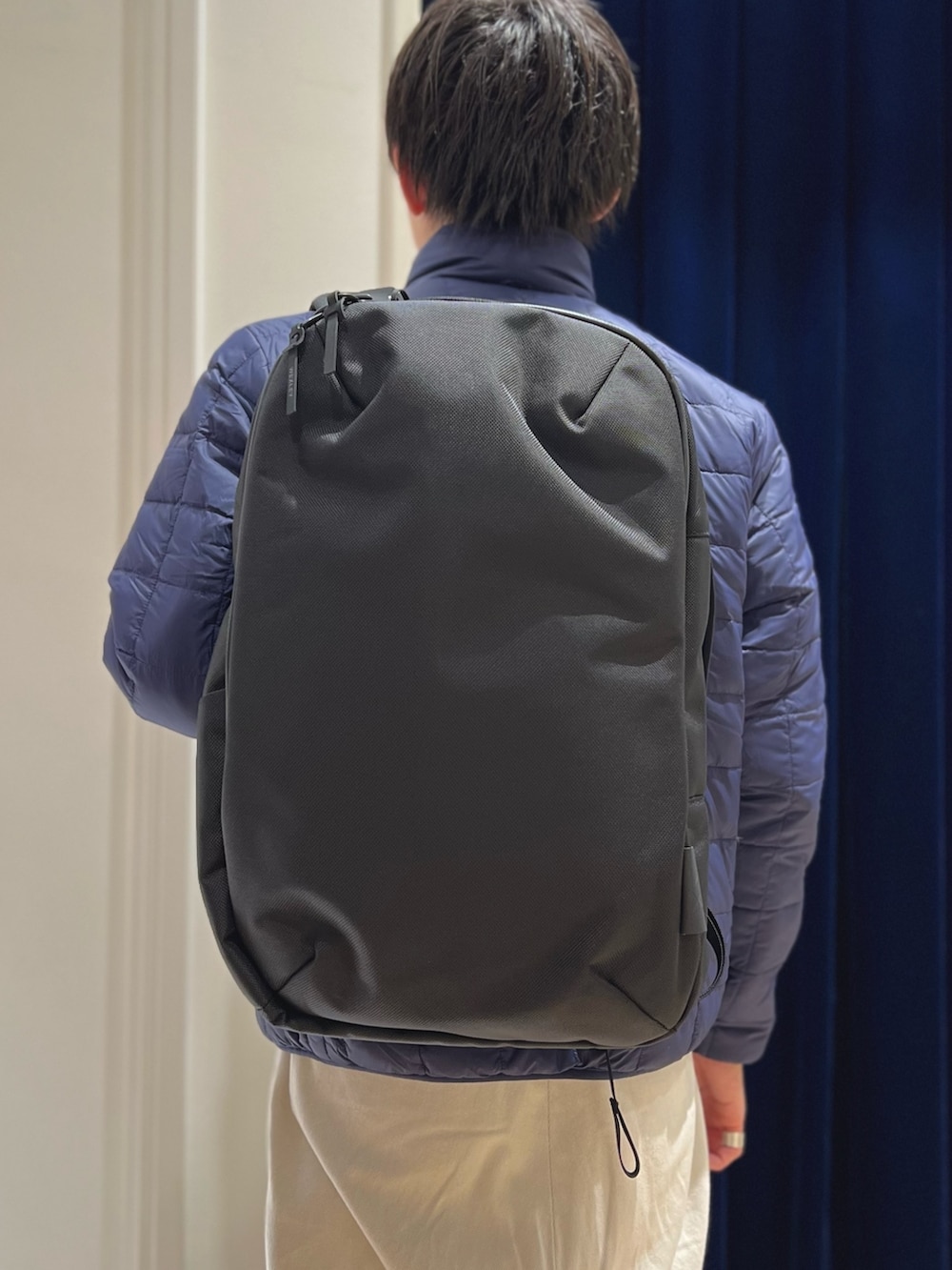 ホワイト系のダウンジャケット/コート、ブラック系のバックパック/リュックを着用したメンズの冬コーディネートの5枚目の写真