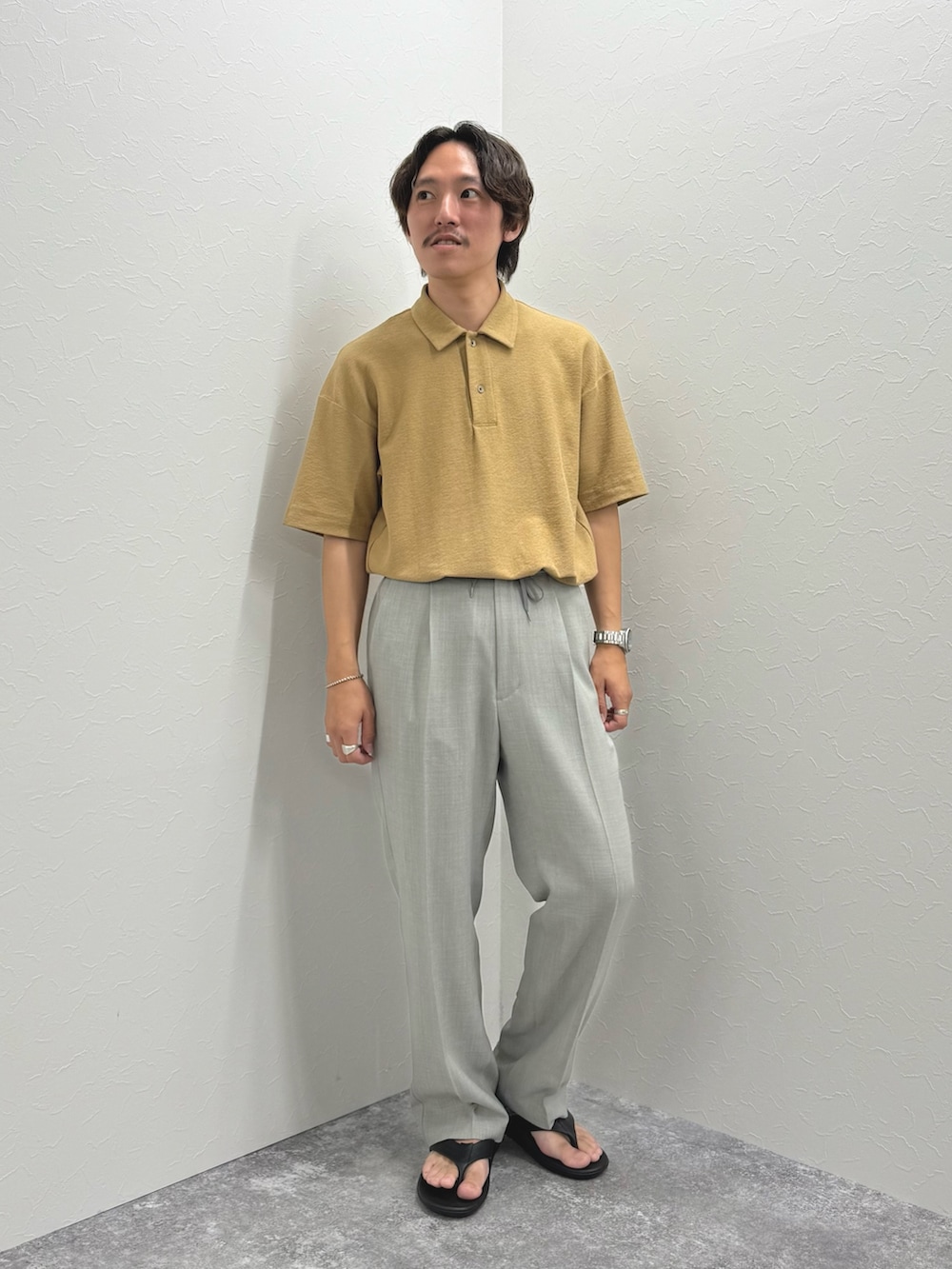 ベージュ系のポロシャツ、ブラック系のサンダルを着用したメンズの夏コーディネートの2枚目の写真