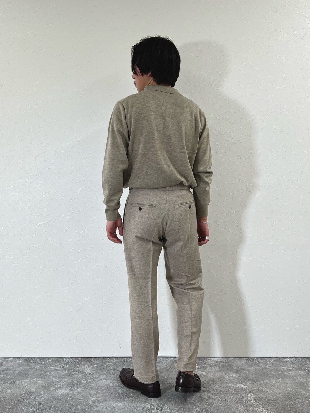 ベージュ系のスラックス、ブラウン系のローファー、ベージュ系のニット/セーターを着用したメンズの冬コーディネートの6枚目の写真