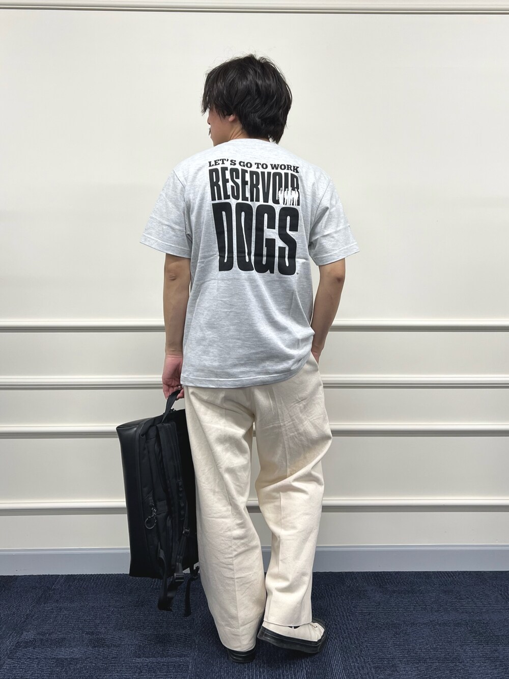 グレー系のTシャツ/カットソー、ブラック系のバックパック/リュック、ホワイト系のデニムパンツを着用したメンズの冬コーディネートの4枚目の写真