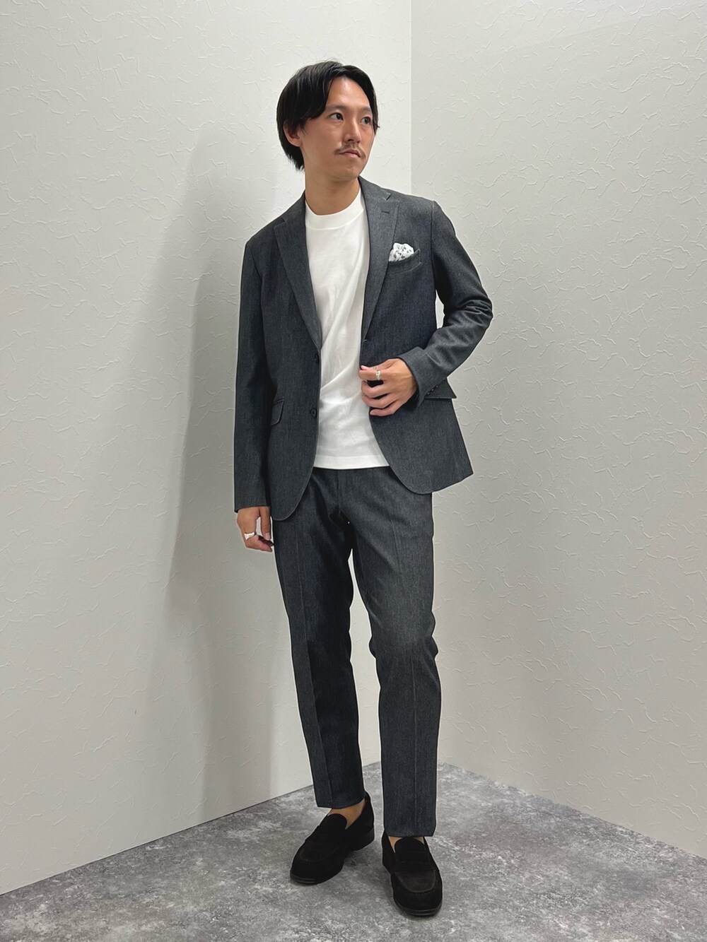 グレー系のテーラードジャケット、ホワイト系のTシャツ/カットソー、グレー系のその他パンツを着用したメンズの秋コーディネートの3枚目の写真