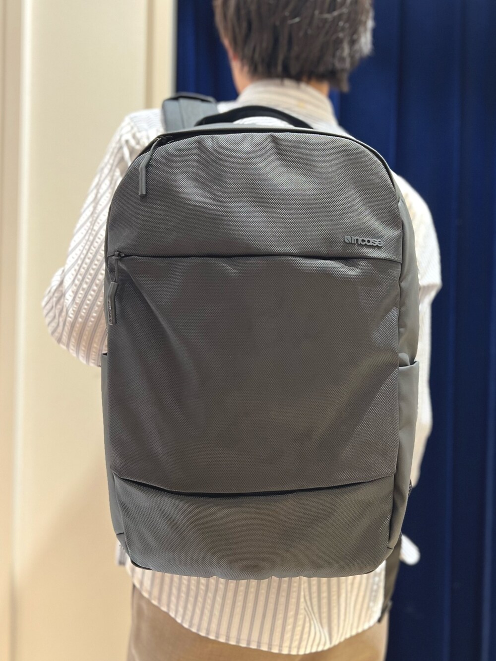 ホワイト系のシャツ/ブラウス、ベージュ系のその他パンツ、ブラック系のバックパック/リュックを着用したメンズの冬コーディネートの6枚目の写真