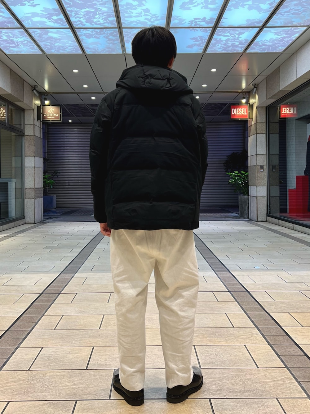 グレー系のスウェット、ブラック系のダウンジャケット/コート、グレー系の手袋を着用したメンズの秋コーディネートの4枚目の写真