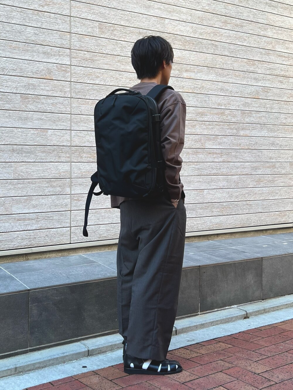 ブラウン系のTシャツ/カットソー、ブラック系のバックパック/リュックを着用したメンズの秋コーディネートの3枚目の写真