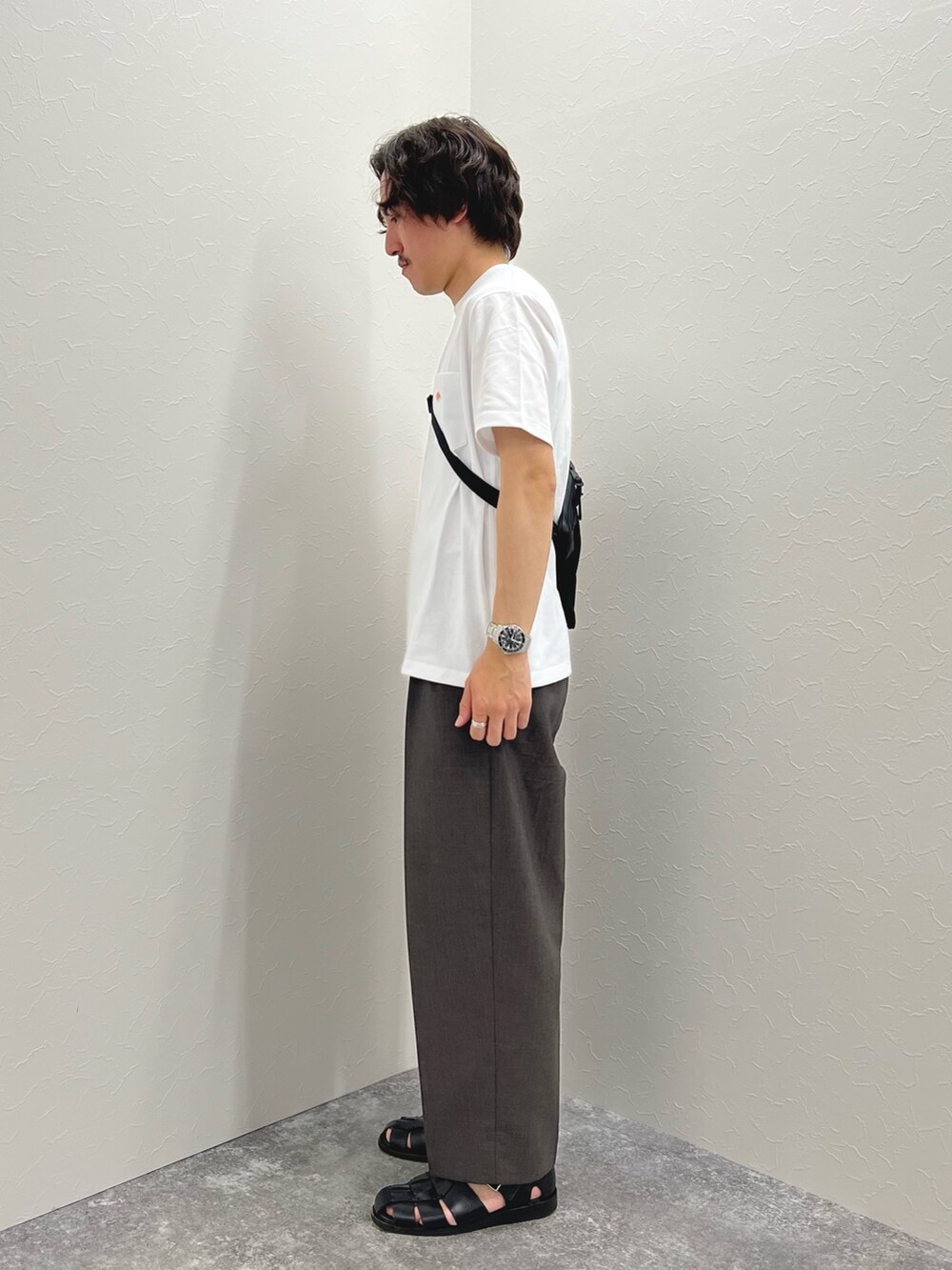 ホワイト系のTシャツ/カットソー、ブラック系のショルダーバッグ、ブラック系のサンダルを着用したメンズの春コーディネートの6枚目の写真