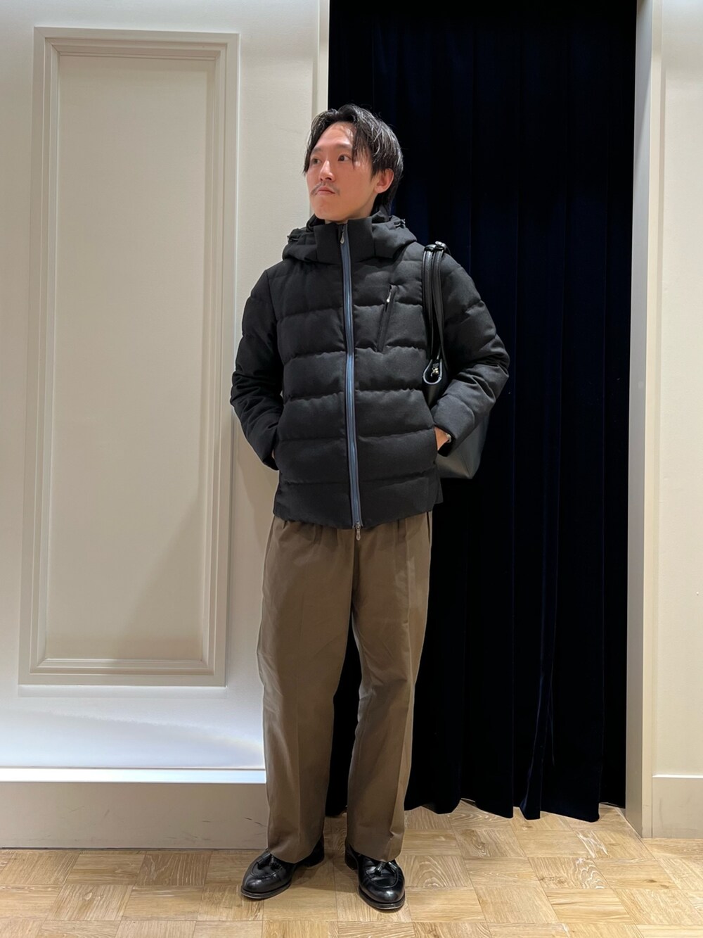 ブラック系のダウンジャケット/コート、ブラック系のトートバッグを着用したメンズの冬コーディネートの2枚目の写真