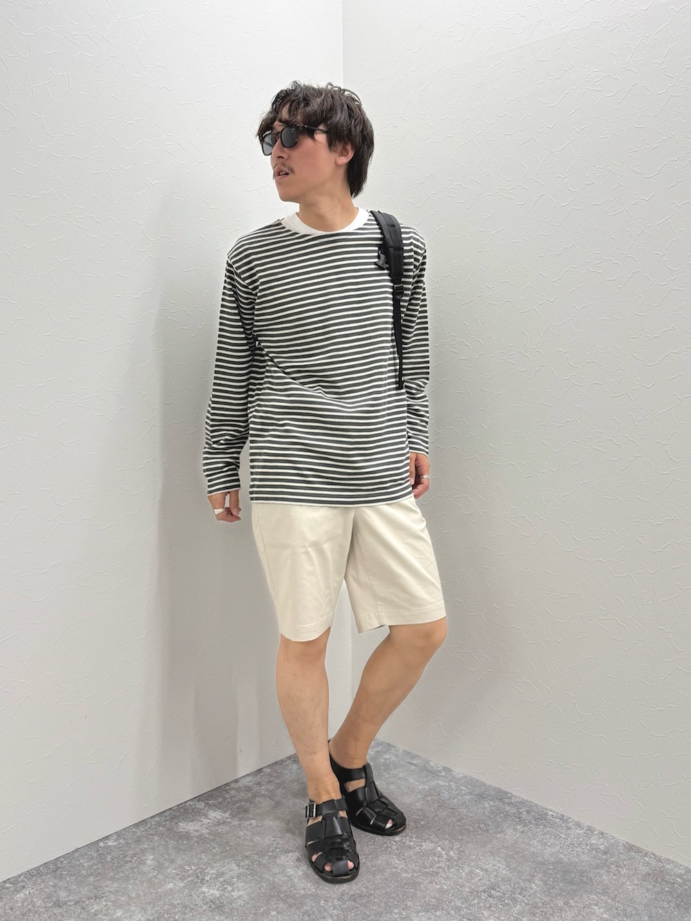 グレー系のTシャツ/カットソー、ホワイト系のその他パンツ、ブラック系のバックパック/リュックを着用したメンズの春コーディネートの2枚目の写真