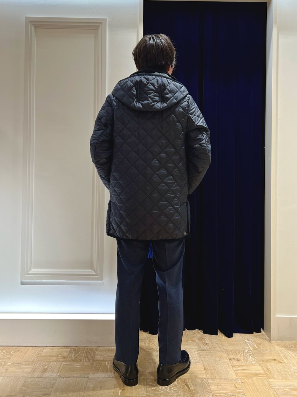 ブルー系のスラックス、ブラック系のローファー、ブルー系のネクタイを着用したメンズの冬コーディネートの5枚目の写真